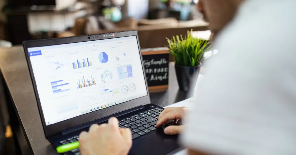A person reviewing data charts on a laptop
