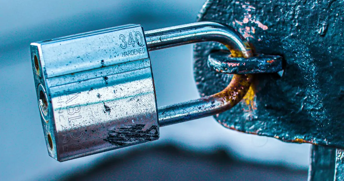 A metal padlock securing a gate